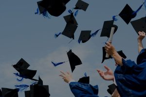 Image of student throwing their graduation caps in the air