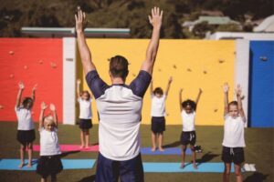 Image of a Trainer teaching children exercise